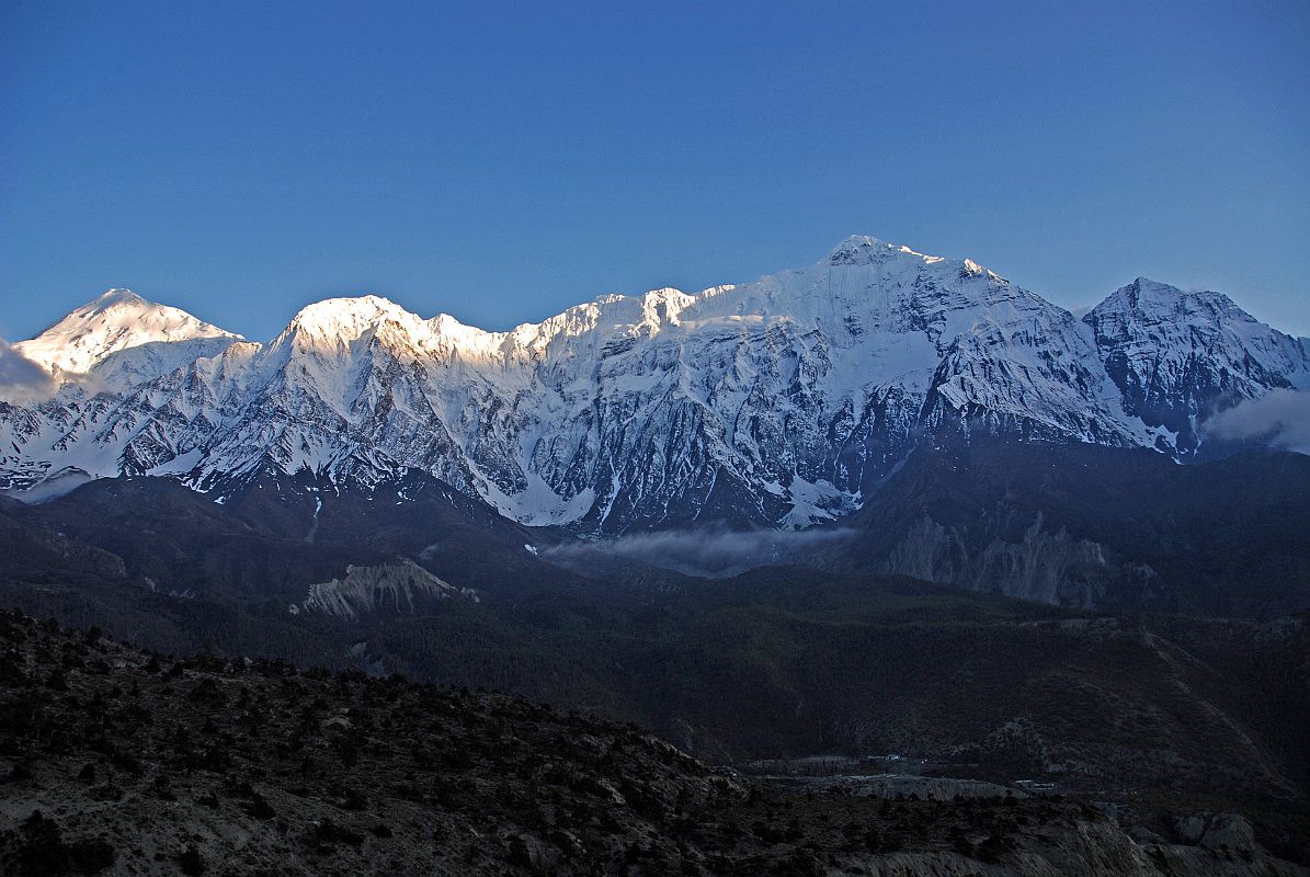 03 Tilicho Peak And Nilgiri North Before Sunset From Kharka On Way To Mesokanto La Tilicho Peak and Nilgiri North shine bright before sunset from our camp on the kharka (3460m) above Jomsom on the way to Tilicho Lake. The Nepalese army restricted military area is across the valley.